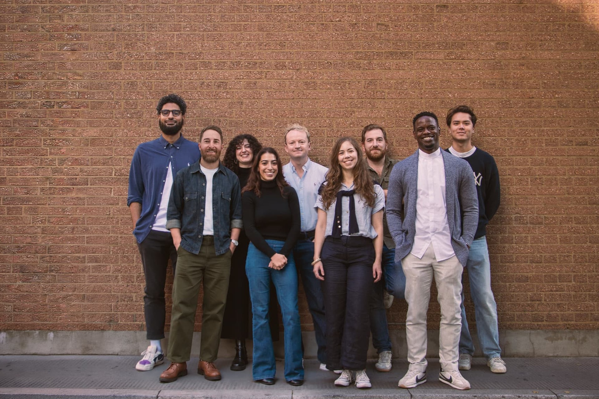 The Double Dice Films team standing together in front of a sunlit brick wall